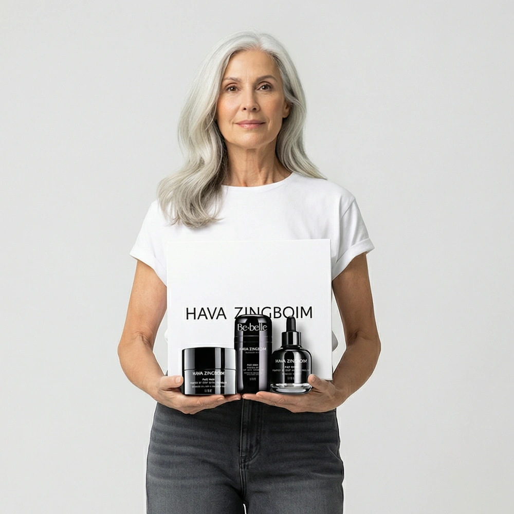 אישה מבוגרת מטופחת ונאה מחזיקה את מוצרי ערכת רימייקרונייזד: קרם+סרום+מסכה