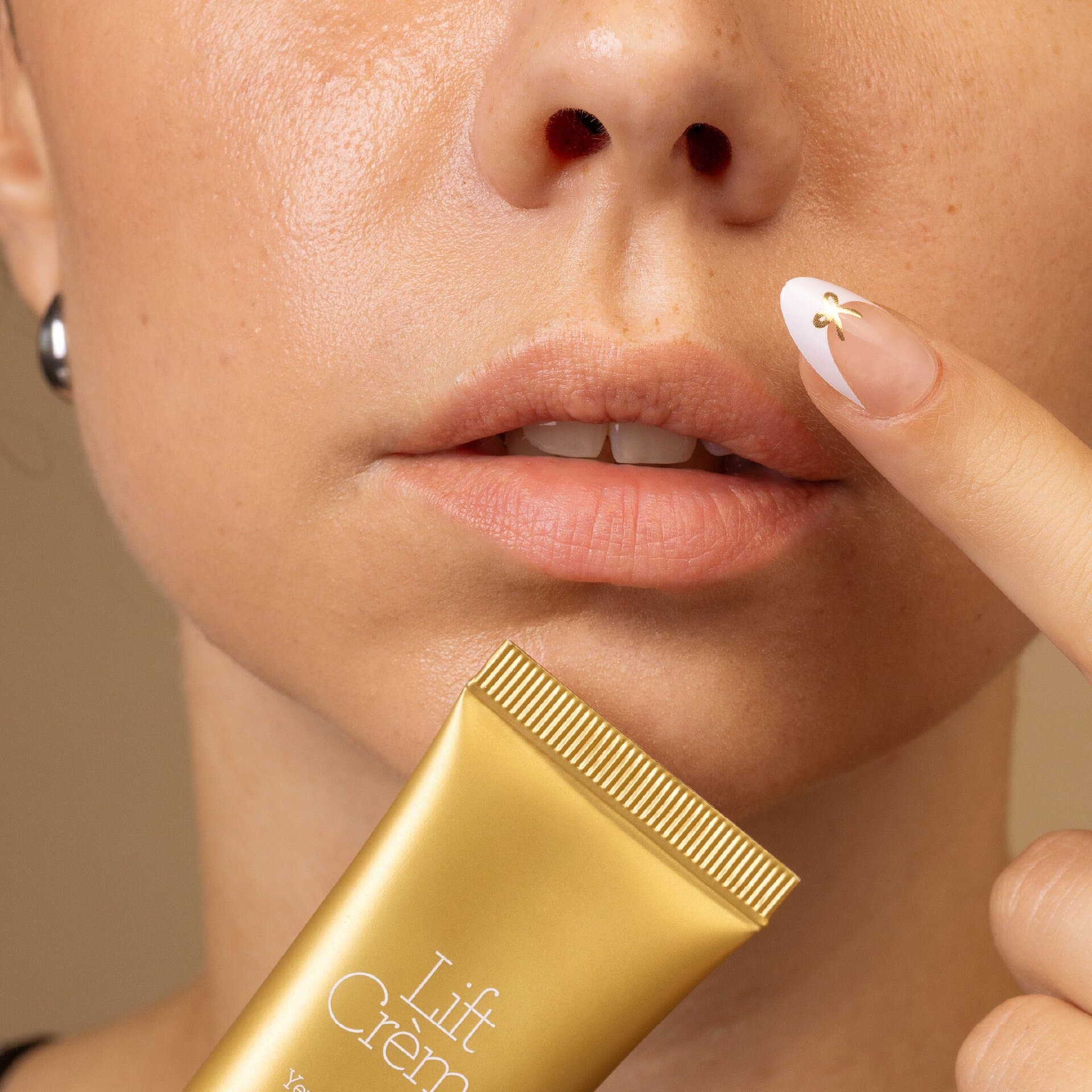Lift Cream של GERnétic - תקריב אישה הנוגעת באזור השפה כששפופרת הקרם נראית בחזית