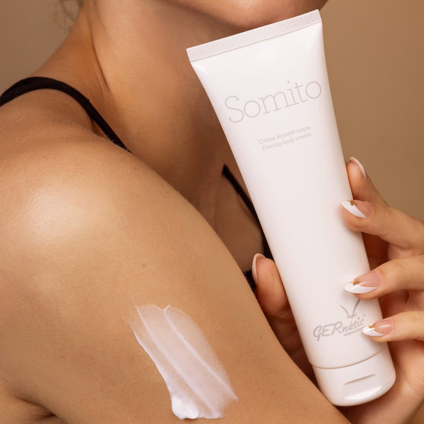 Somito של GERnétic – אישה מחזיקה שפופרת סומיטו ליד הזרוע שעליה מריחת קרם לבן