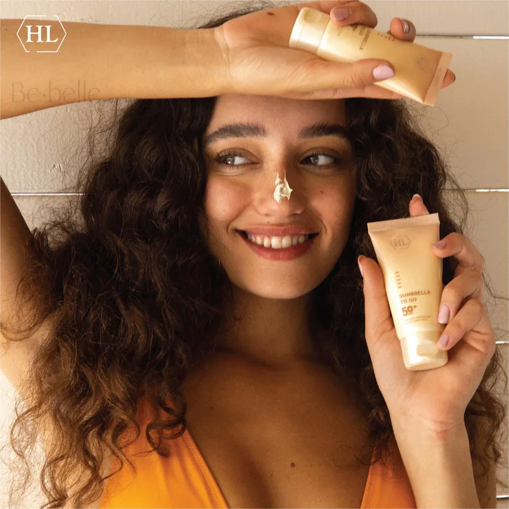מודליסטית מחזיקה HL SUNBRELLA SPF 50+ – קרם הגנה לפנים ללא גוון 50 מ״ל – שפופרת בהירה בגוון שמנת, מכסה שקוף, סימון SUNBRELLA TO GO SPF 50+; נפח 50 מ״ל.